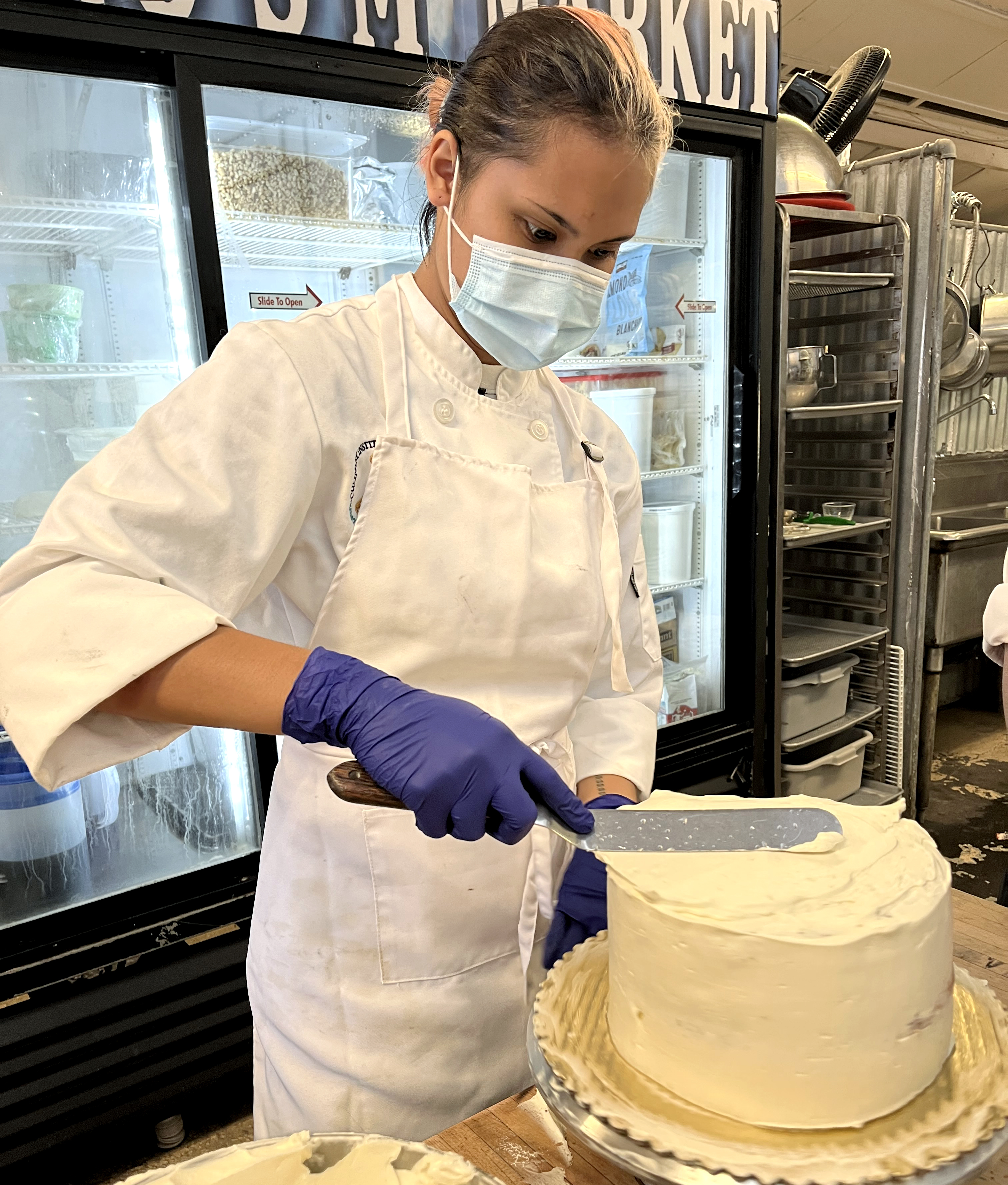 Sydirah Aricayos frosts a cake at Short N Sweet Bakery.