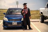 photo of graduate posing with car