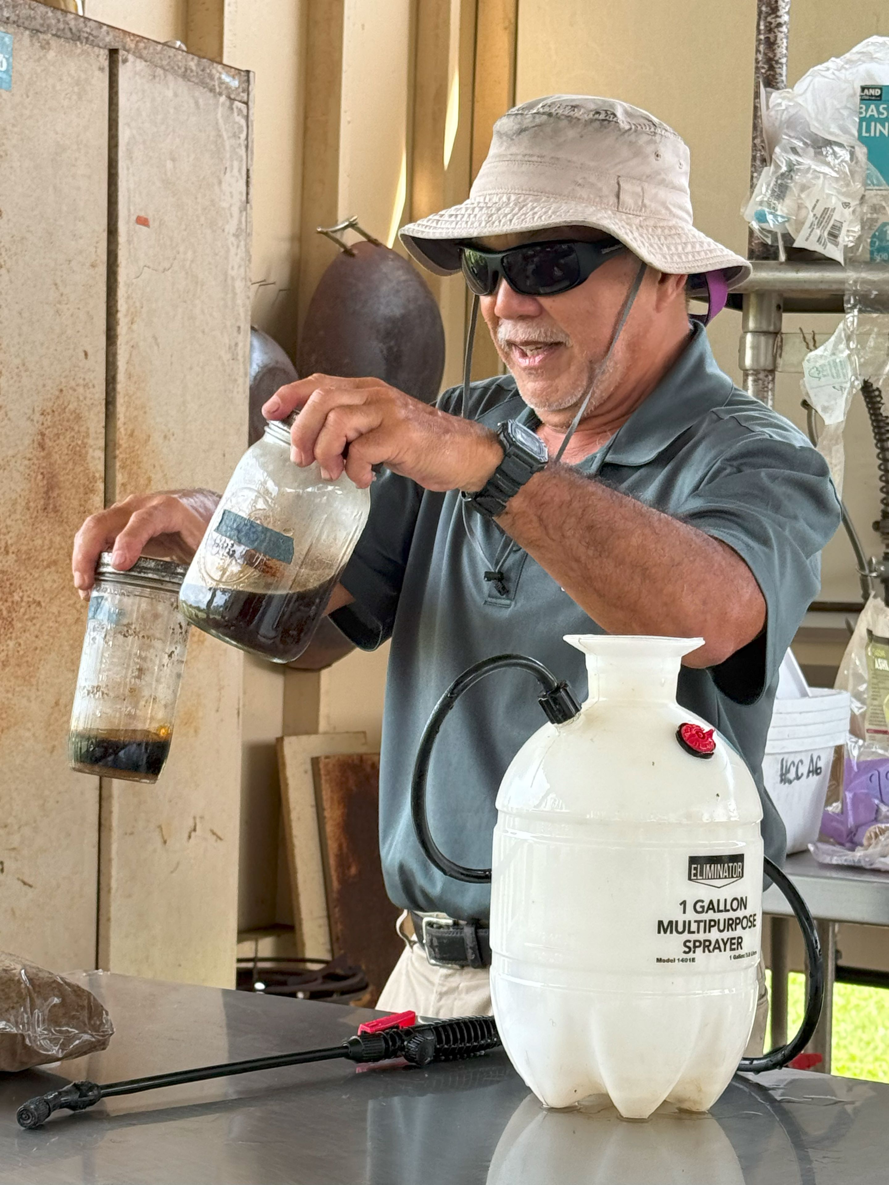 Hawaii CC Agriculture program assistant professor Lew Nakamura mixes fermented plant juice with lactic acid bacteria and water to inoculate the IMO.