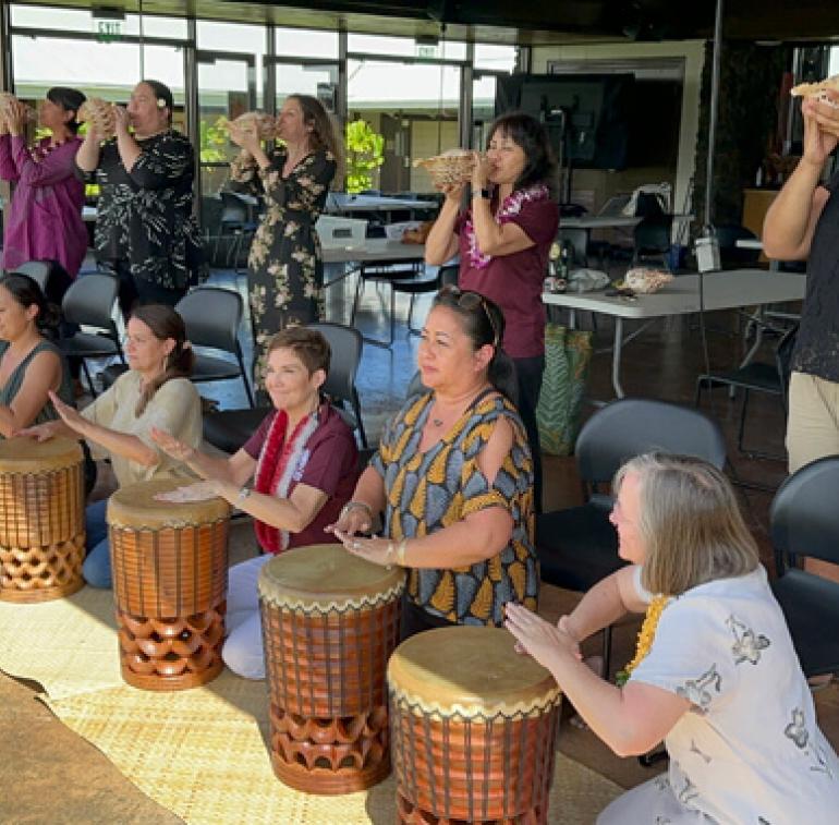 President Hensel takes part in a workshop exploring the elements of the Kīpaepae ceremony. During the session, she learned to hoʻokani the pahu (to drum) and pū (blow the conch shell), discovering the meaning behind this tradition.